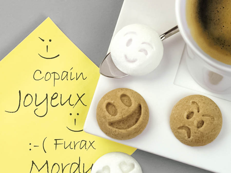 顔文字を模ったおしゃれな角砂糖とホットコーヒー