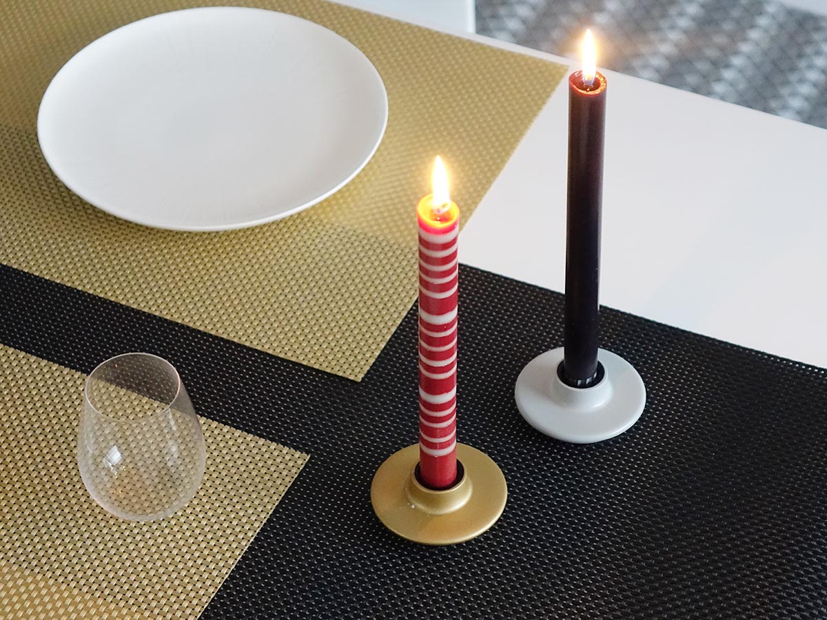 チルウィッチのゴールドのランチョンマットと黒のテーブルランナーのアクセントに赤白ボーダーのディナーキャンドルと黒単色のテーパーキャンドルと木製のゴールドとライトグレーのキャンドルホルダー