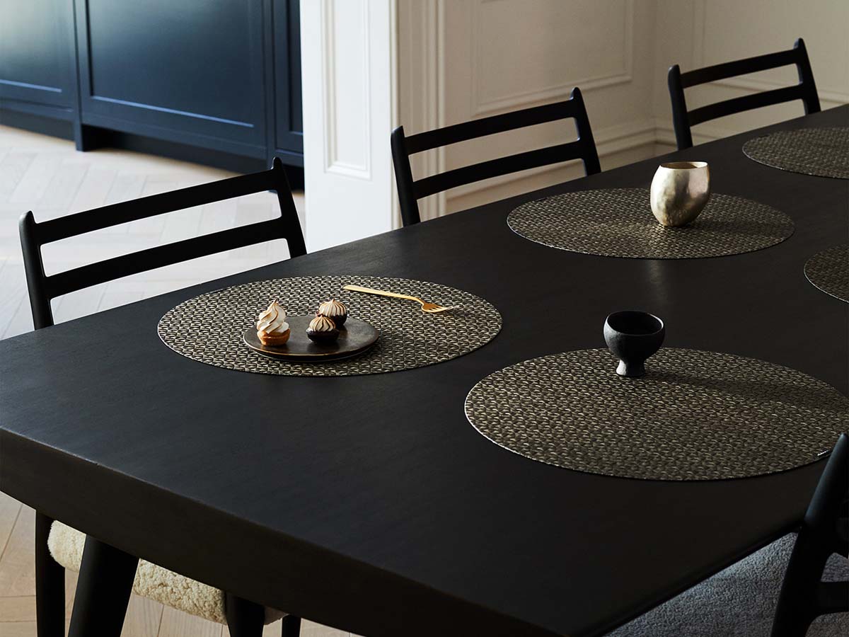 黒のテーブルに合わせた多面体で光沢のある茶色のチルウィッチの円形ランチョンマット