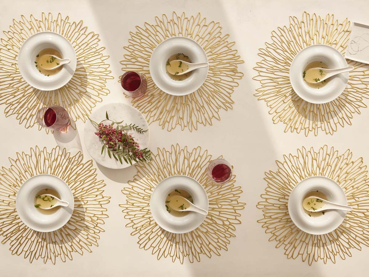 白のテーブルに合わせた花を模ったゴールドのチルウィッチの円形ランチョンマット