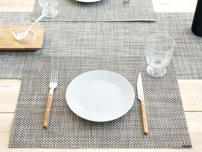 オークのテーブルに合わせたグレイとホワイトの平織りのランチョンマット