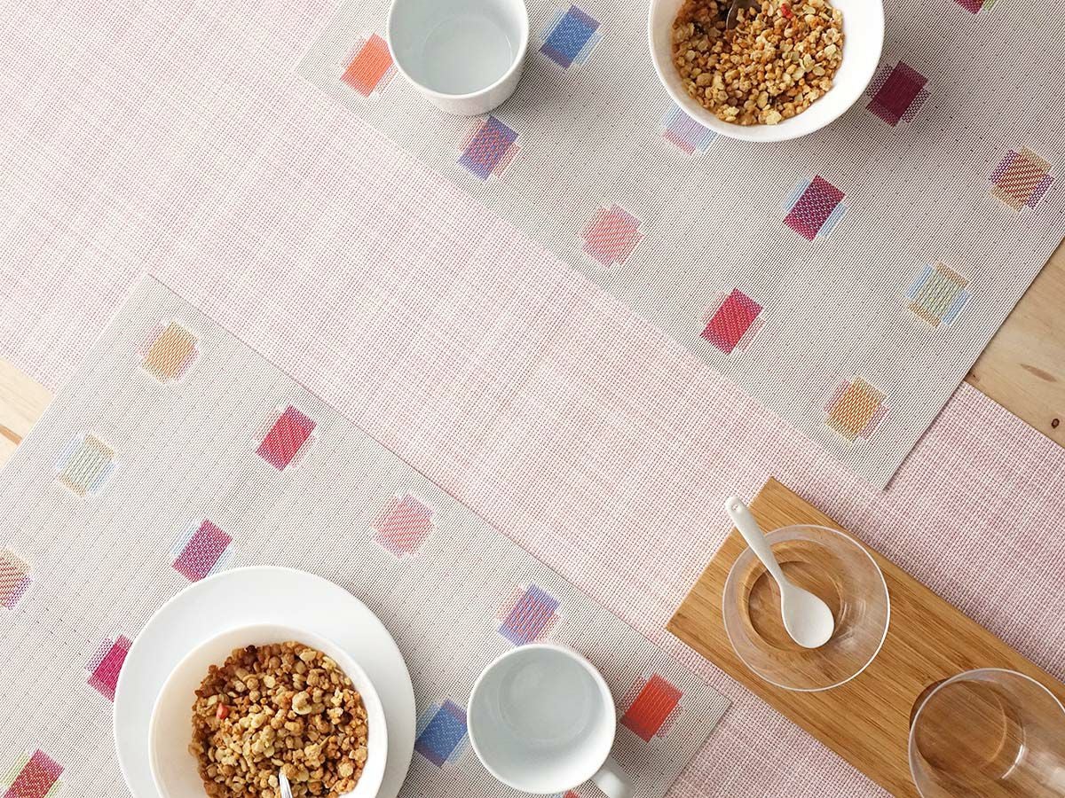 茶色のテーブルに合わせた平織りのベビーピンクのテーブルランナーとチェックのランチョンマット