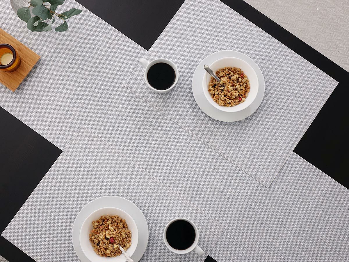 黒のテーブルに合わせた平織りのスカイブルーのテーブルランナーとランチョンマット