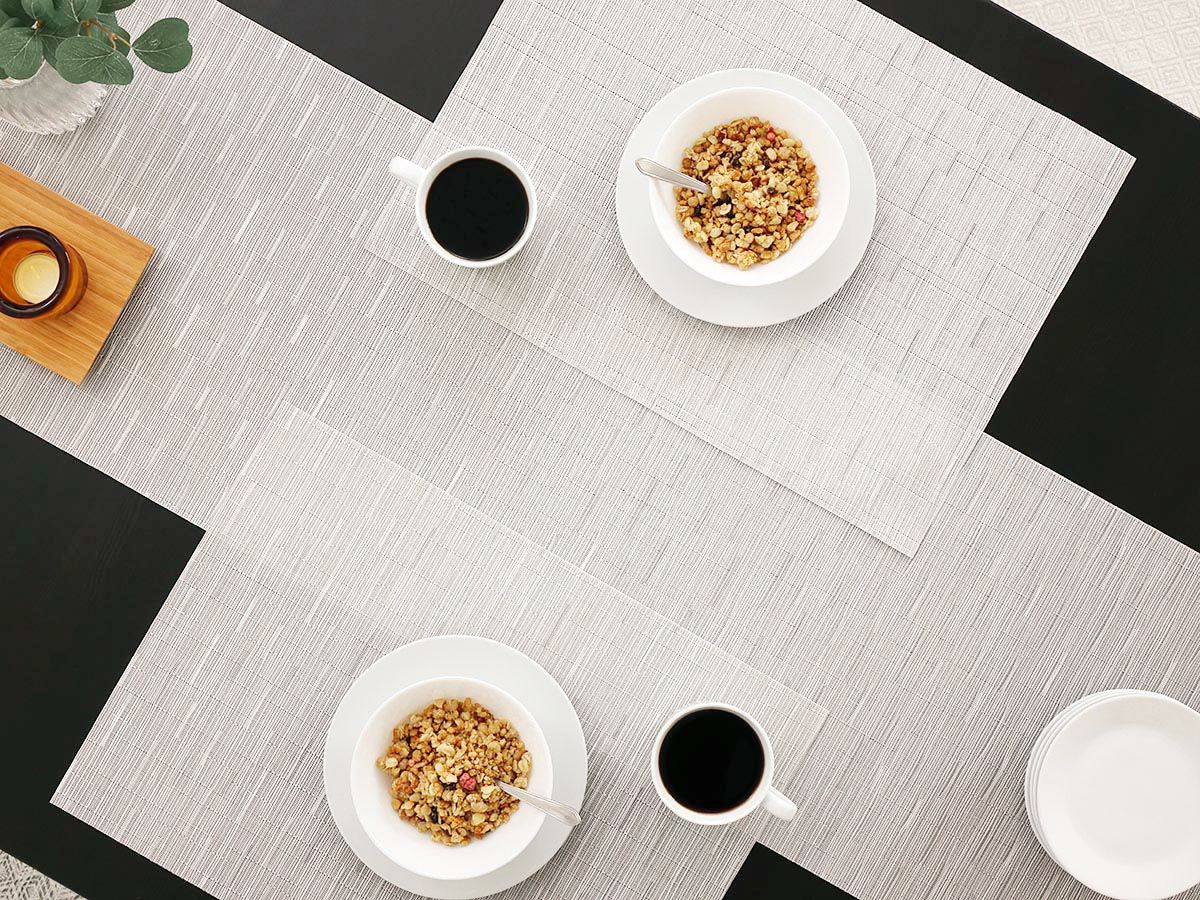 黒のテーブルに合わせた竹の節のようなストライプで透明感のあるシルバーのランチョンマットとテーブルランナー