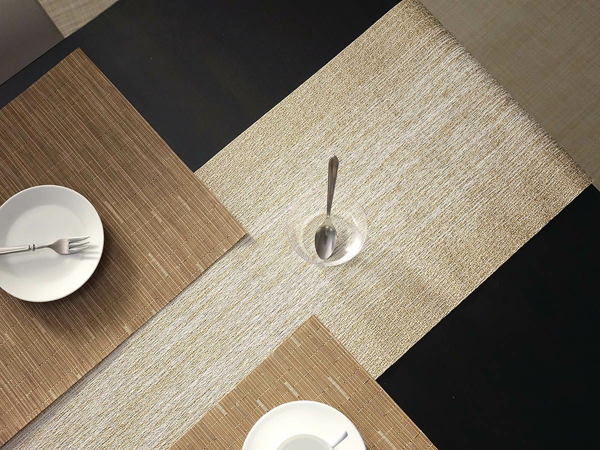 黒色のテーブルに合わせたホワイトとゴールドのグラデーションのテーブルランナーとゴールドのランチョンマット