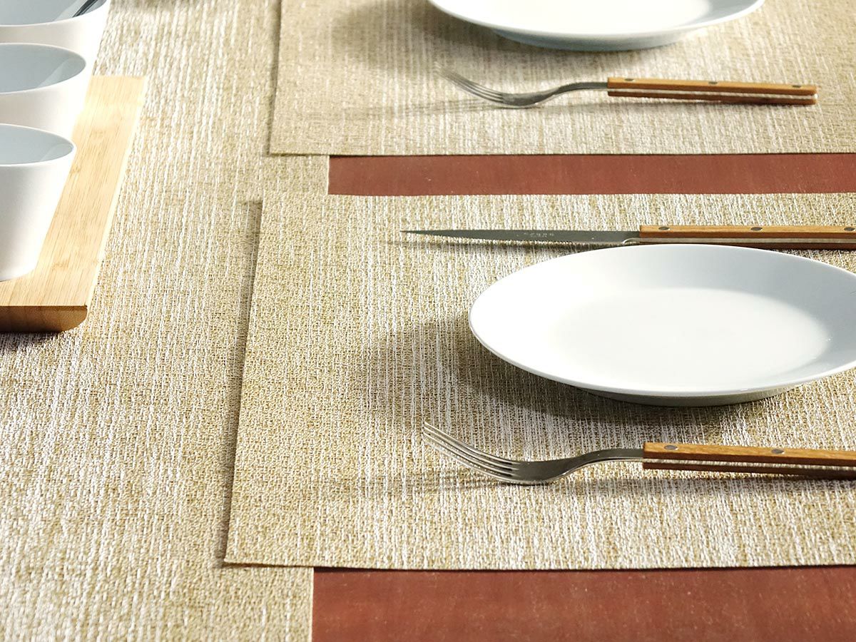 黒色のテーブルに合わせたホワイトとゴールドのグラデーションのテーブルランナーとゴールドのランチョンマット