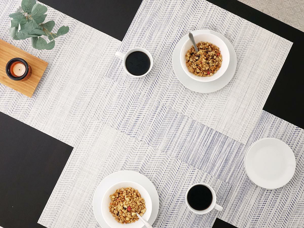 黒色のテーブルに合わせた波模様のブルーのテーブルランナーとランチョンマット