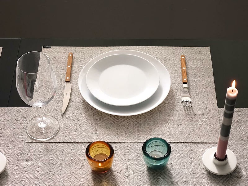 取っ手が木製のクラシカルなカトラリーと白の16cmプレートを際立たせるグレーのランチョンマット　ベージュとグレイグリーンのティライトホルダーとピンクグレイのボーダーのテーパーキャンドルがアクセントになるテーブルセッティング