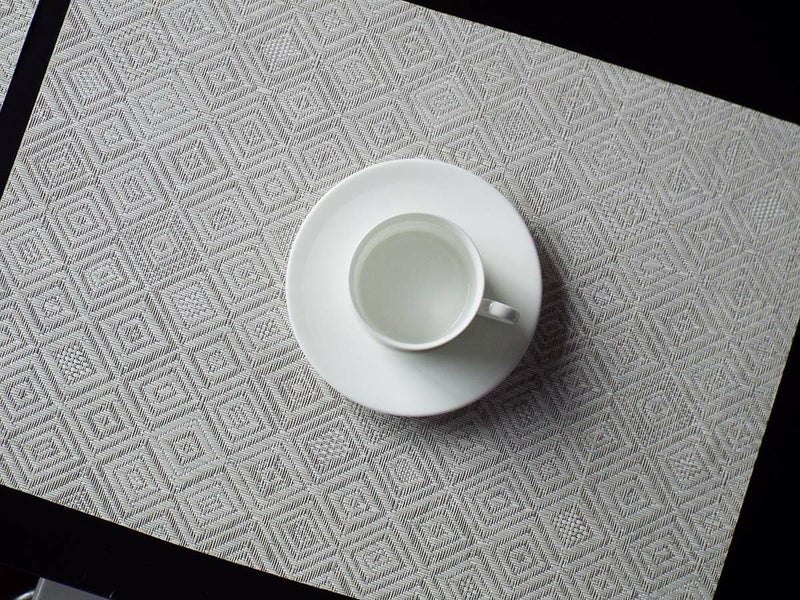 大きさやデザインが様々な擦れたダイヤモンドパターンのグレイのランチョンマット