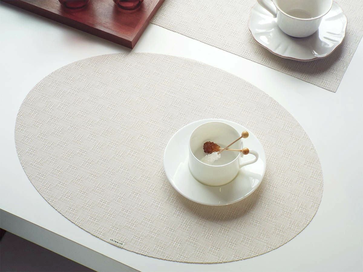 白いテーブルに合わせた白色のレースの市松模様の楕円形のランチョンマット