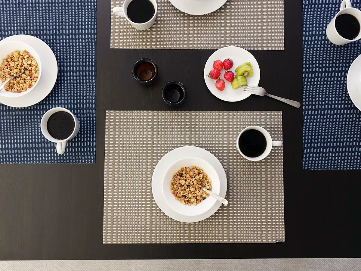 黒のテーブルに合わせたグレイのウネリのあるストライプのランチョンマット