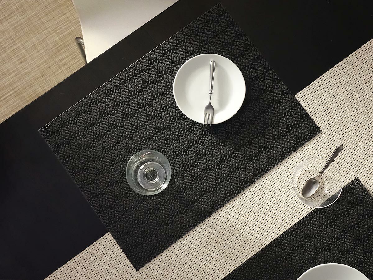 黒のテーブルに合わせた濃淡の黒色の扇模様が連続したランチョンマットとベージュの平織りのテーブルランナー